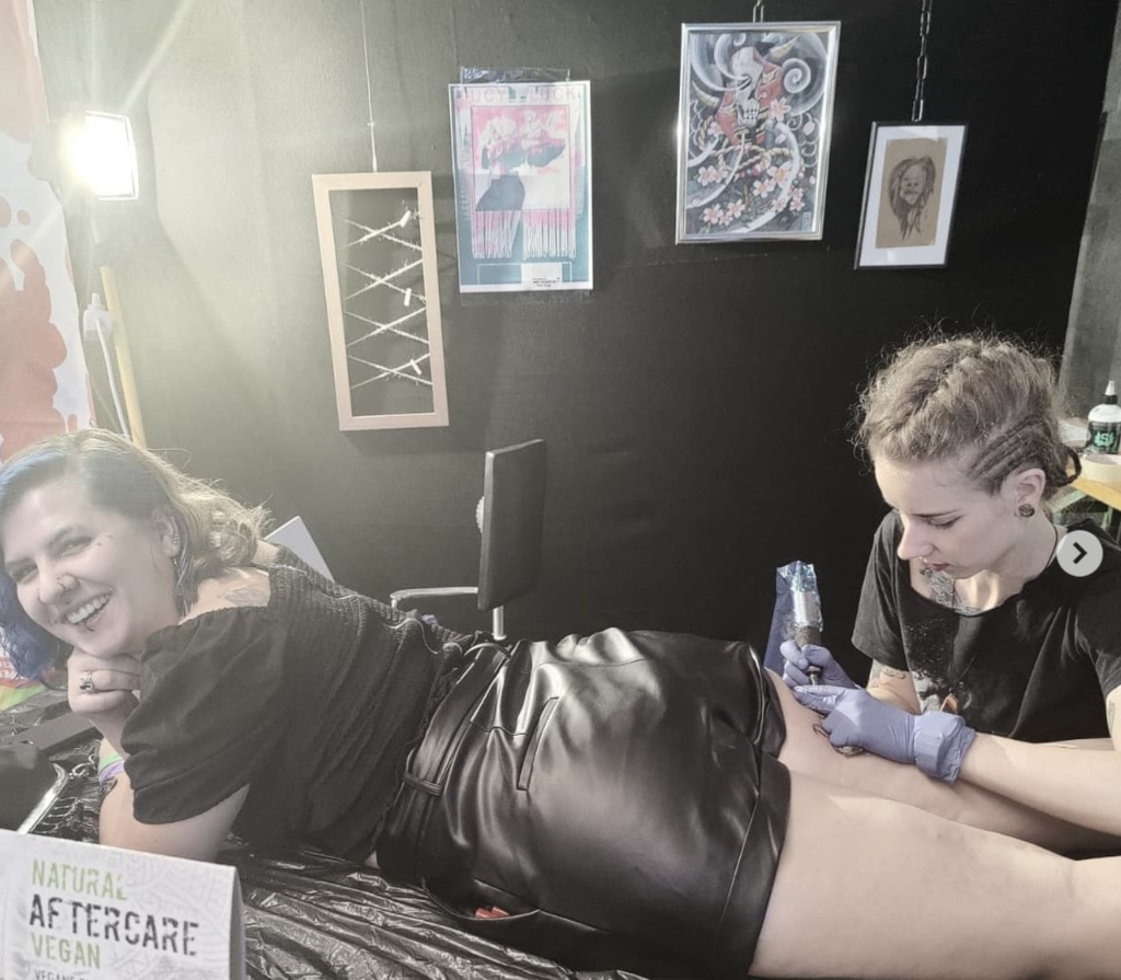 Lucy tattooing Tynki on the back of the leg at the Wildstyle-Tattoo-Convention